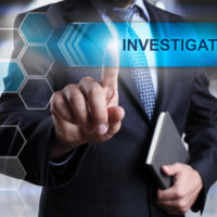 Business man pointed to a Discrimination Complaint Investigation sign.jpg.crdownload Business man pointed to a Discrimination Complaint Investigation sign.jpg.crdownload