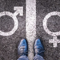 male and female gender symbols on asphalt below legs