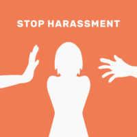 orange sign that reads stop harassment