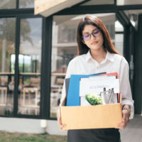 business woman fired walks out with stuff in box business woman fired walks out with stuff in box