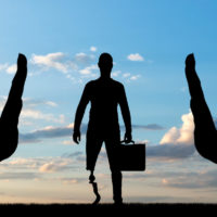 silhouette of two hands making stop sign at disabled worker