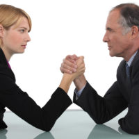 Businessman and woman arm wrestling