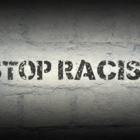 stop racism stencil print on brick wall