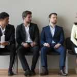 Diverse male applicants looking at female rival waiting for interview