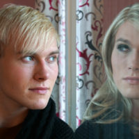 man looks in reflection sees female version of self