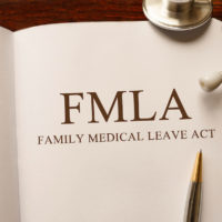 Page in FMLA book on the table with stethoscope and pencil on table Page in FMLA book on the table with stethoscope and pencil on table