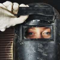 female welder wearing helmet