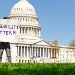 Protester boy holding sign disability matters hiding face