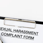 Sexual Harassment Complaint Form on attached on Clip board and pen on white background Sexual Harassment Complaint Form on attached on Clip board and pen on white background
