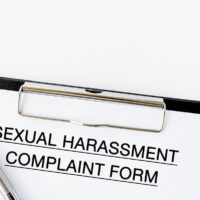 Sexual Harassment Complaint Form on attached on Clip board and pen on white background