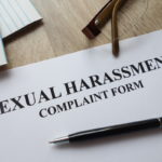 Sexual harassment complaint form with pen, calculator and glasses on desk Sexual harassment complaint form with pen, calculator and glasses on desk