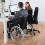 Disabled employee in wheelchair, talking with boss Disabled employee in wheelchair, talking with boss