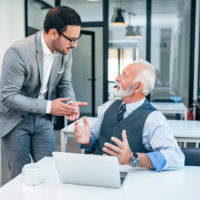 Young man encouraging older worker to retire