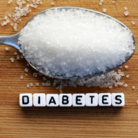 Diabetes block letters in crossword and sugar pile on a spoon