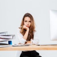 Upset sad businesswoman sitting at her working place