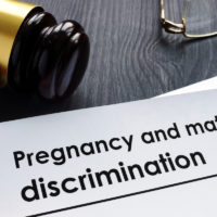 Documents about pregnancy and maternity discrimination and gavel.