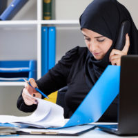 Muslim office worker on phone