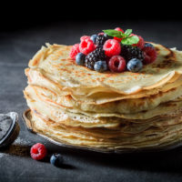 Big stack of pancakes with blueberries and raspberries
