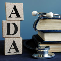 ADA (American Disabilities Act) in block letters with stethoscope and books