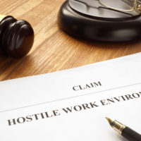 hostile work environment claim form next to pen and gavel on table
