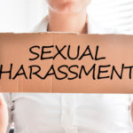 sexual harassment text on cardboard sign