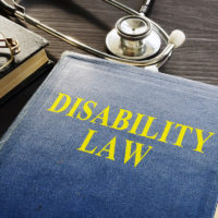 Disability Law book and stethoscope on a desk. Disability Law book and stethoscope on a desk.