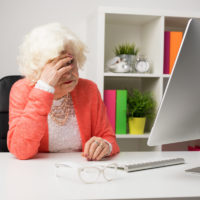 Older woman at the office having headache