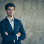 Photo of candid serious pensive pondering man with arms crossed having bristle staring at you near empty space isolated grey color background