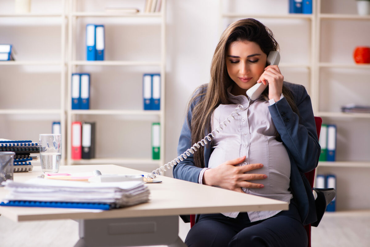 Young pregnant woman working in the office