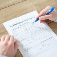 Hand filling the unemployment benefit application