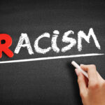 Racism text on blackboard, social concept background