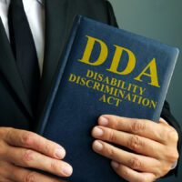 Lawyer is holding Disability Discrimination Act DDA. Lawyer is holding Disability Discrimination Act DDA.