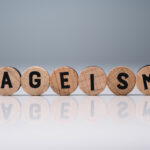 Ageism Text On Round Blocks Over White Desk