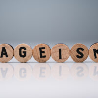 Ageism Text On Round Blocks Over White Desk