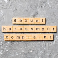 Sexual harassment complaint word written on wood block. Sexual harassment complaint text on table, concept