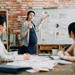 pregnant businesswoman leads boardroom meeting.