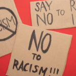 top view of carton placards with no to racism lettering on red background