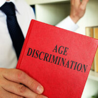 A lawyer shows an Age discrimination law book in the office. A lawyer shows an Age discrimination law book in the office.