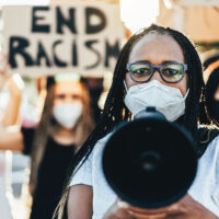 People from different ages and races protest on the street for equal rights - Demonstrators wearing face masks during black lives matter fight campaign - Focus on woman face