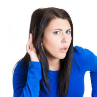 unhappy hard of hearing woman hand on ear asking to speak up