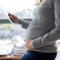 pregnant businesswoman with tablet pc at office