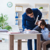 Pregnant woman struggling in the office and getting colleague he