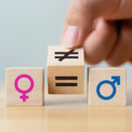 Concepts of gender equality. Hand flip wooden cube with symbol unequal change to equal sign