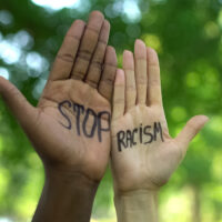 Interracial people hands with stop racism phrase, fight against discrimination
