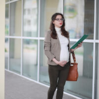 Pregnant woman talking on the phone in the street