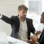Rude white partner telling black businessman get out his office