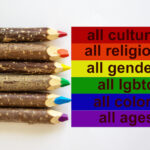 LGBT colors corrugated cardboard flag. Pencils lie on top Bright social colors lgbt. Diversity ethnicity gender age sexual orientation religion disability words. Copy space. Equality and diversity concept.