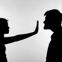 Man abusing woman, silhouette on a white background. Stop sexual assault