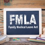 fmla, family medical leave act. Chalkboard on a wooden background