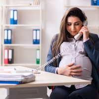 Young pregnant woman working in the office